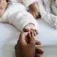 Baby and parent holding hands